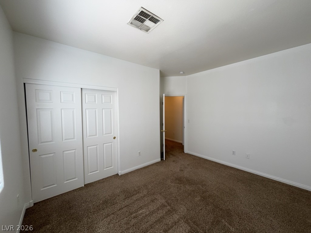 4915 East Russell Road, Unit 159 Las Vegas, NV 89120 - Photo 7 of 12 Unfurnished bedroom with dark colored carpet and a closet