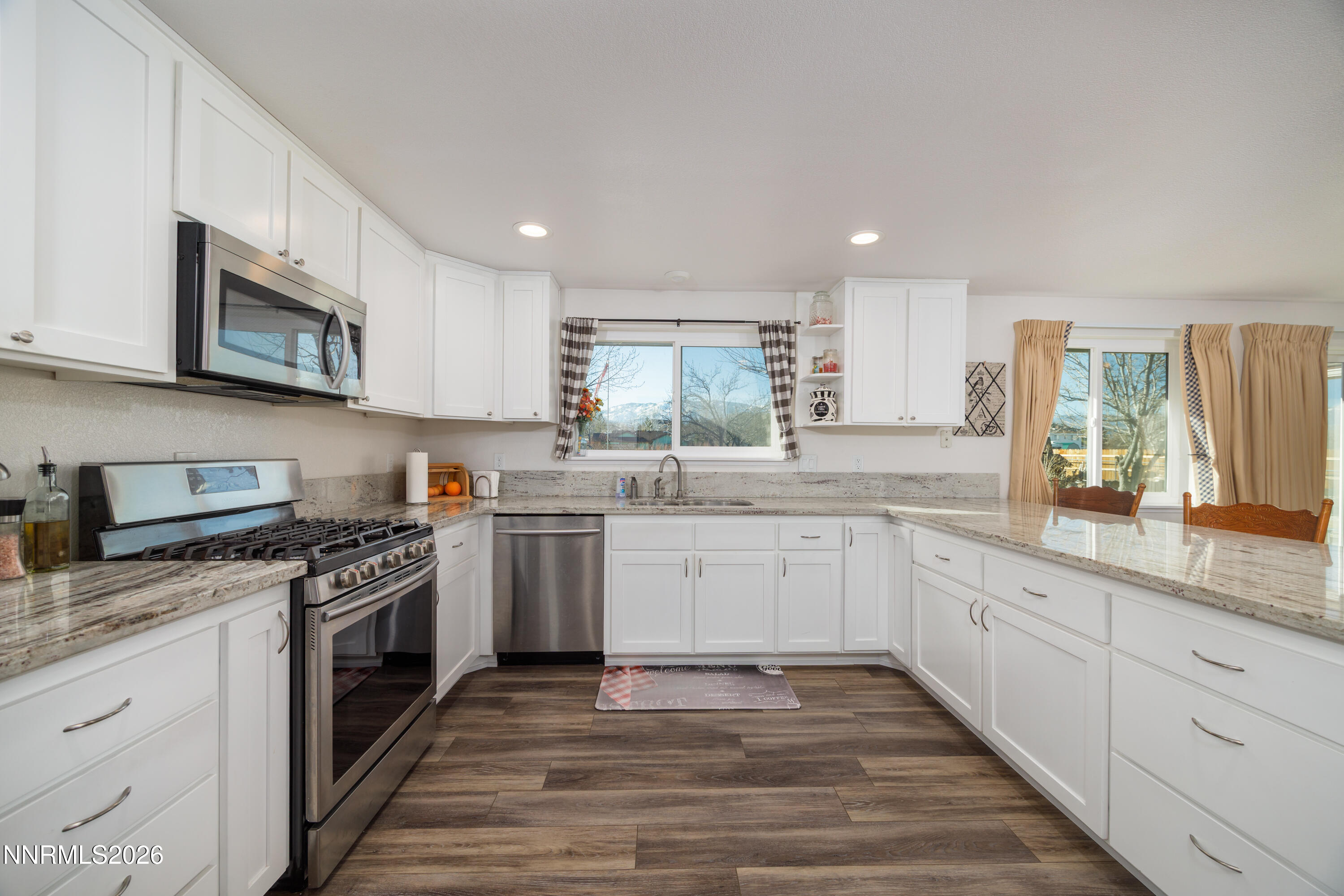 450 Riparian Way Carson City, NV 89701 - Photo 4 of 27 a kitchen with stainless steel appliances granite countertop a stove top oven a sink dishwasher and a microwave oven with white cabinets