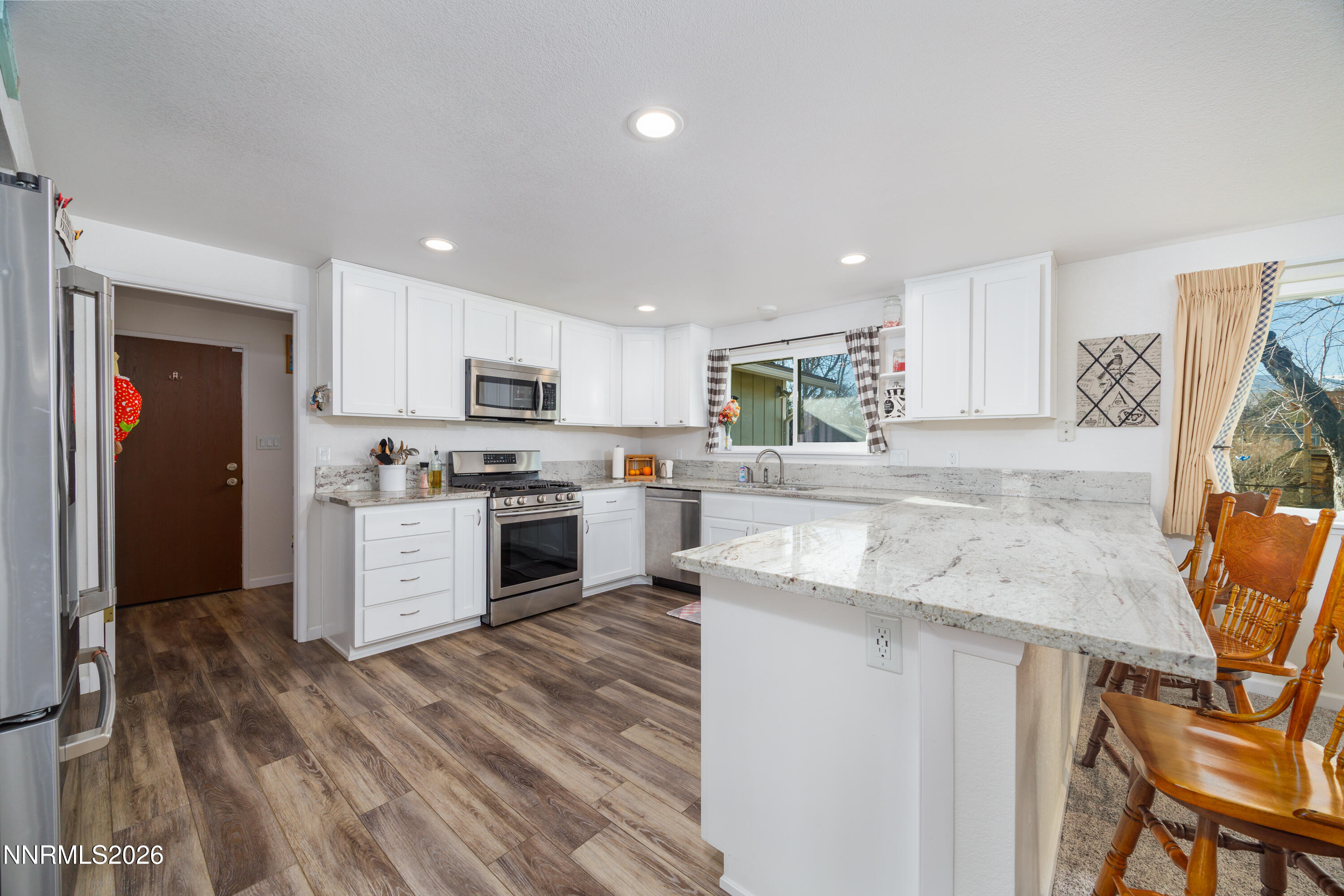 450 Riparian Way Carson City, NV 89701 - Photo 5 of 27 a kitchen with granite countertop white cabinets and refrigerator