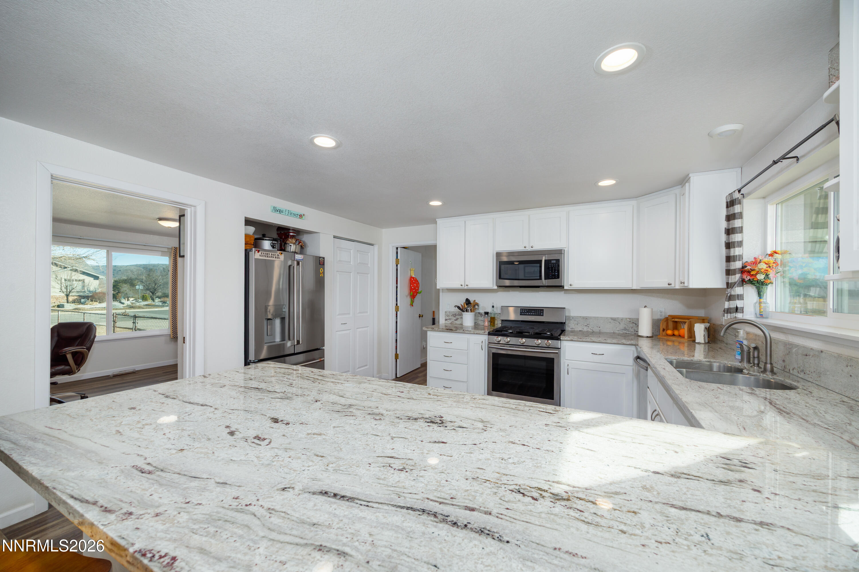 450 Riparian Way Carson City, NV 89701 - Photo 6 of 27 a large kitchen with stainless steel appliances granite countertop a stove oven a sink dishwasher and a refrigerator with wooden floor