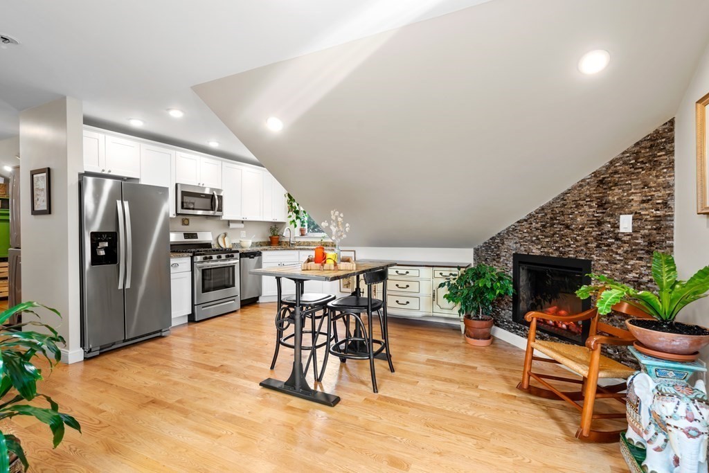 1-3 Howard Place, Unit B Boston, MA 02125 - Photo 1 of 25 a kitchen with stainless steel appliances kitchen island granite countertop a refrigerator and a stove top oven
