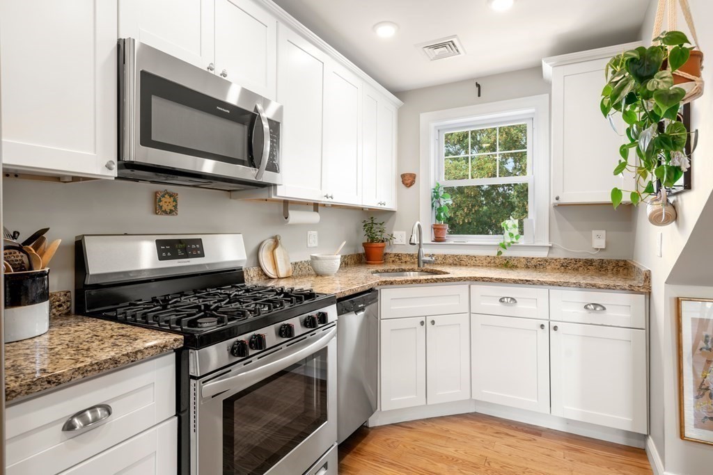 1-3 Howard Place, Unit B Boston, MA 02125 - Photo 2 of 25 a kitchen with stainless steel appliances granite countertop white cabinets a window and a sink