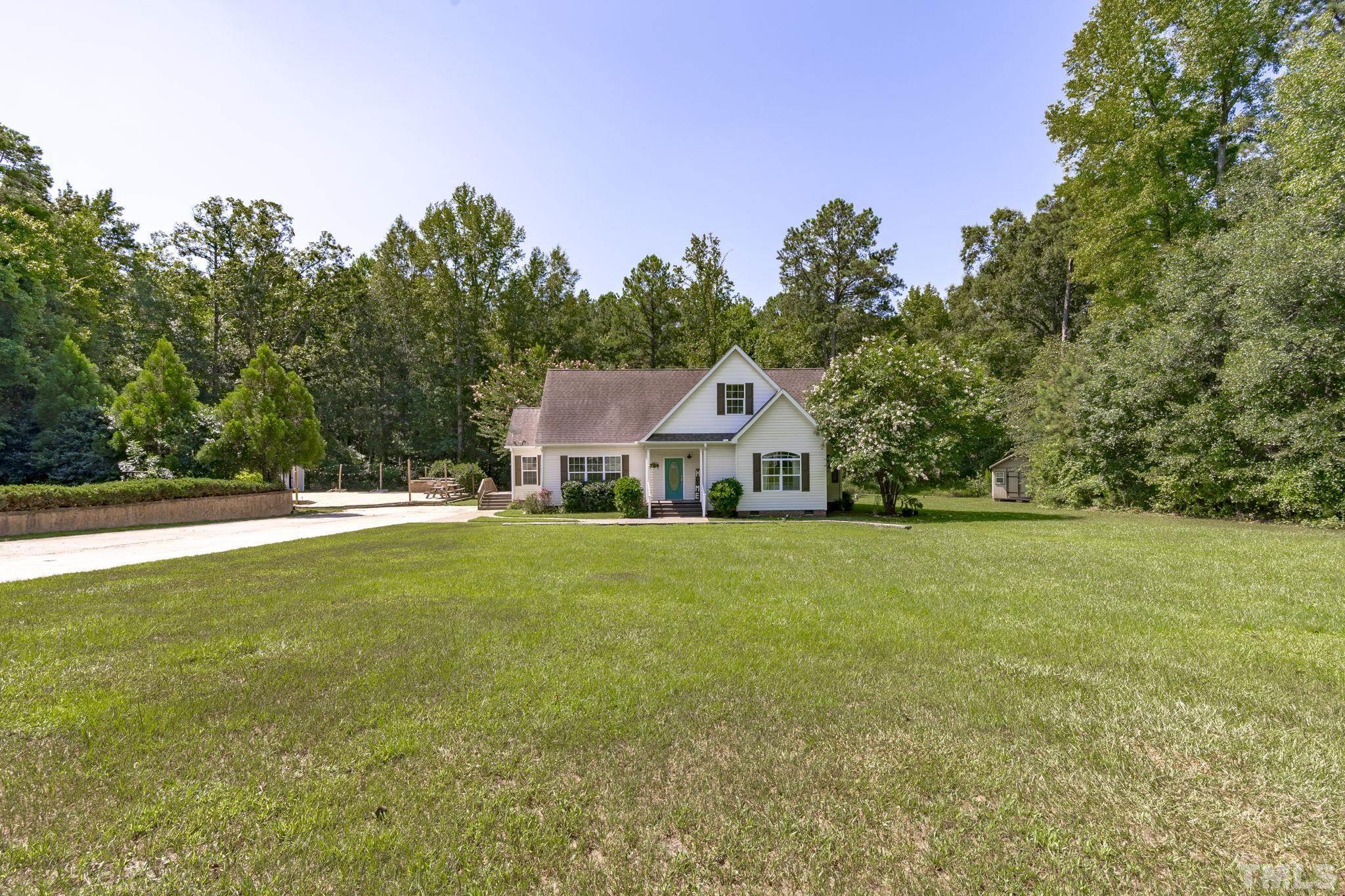 4236 Rockside Hills Drive Raleigh, NC 27603 - Photo 3 of 28 a view of a house next to a big yard with large trees