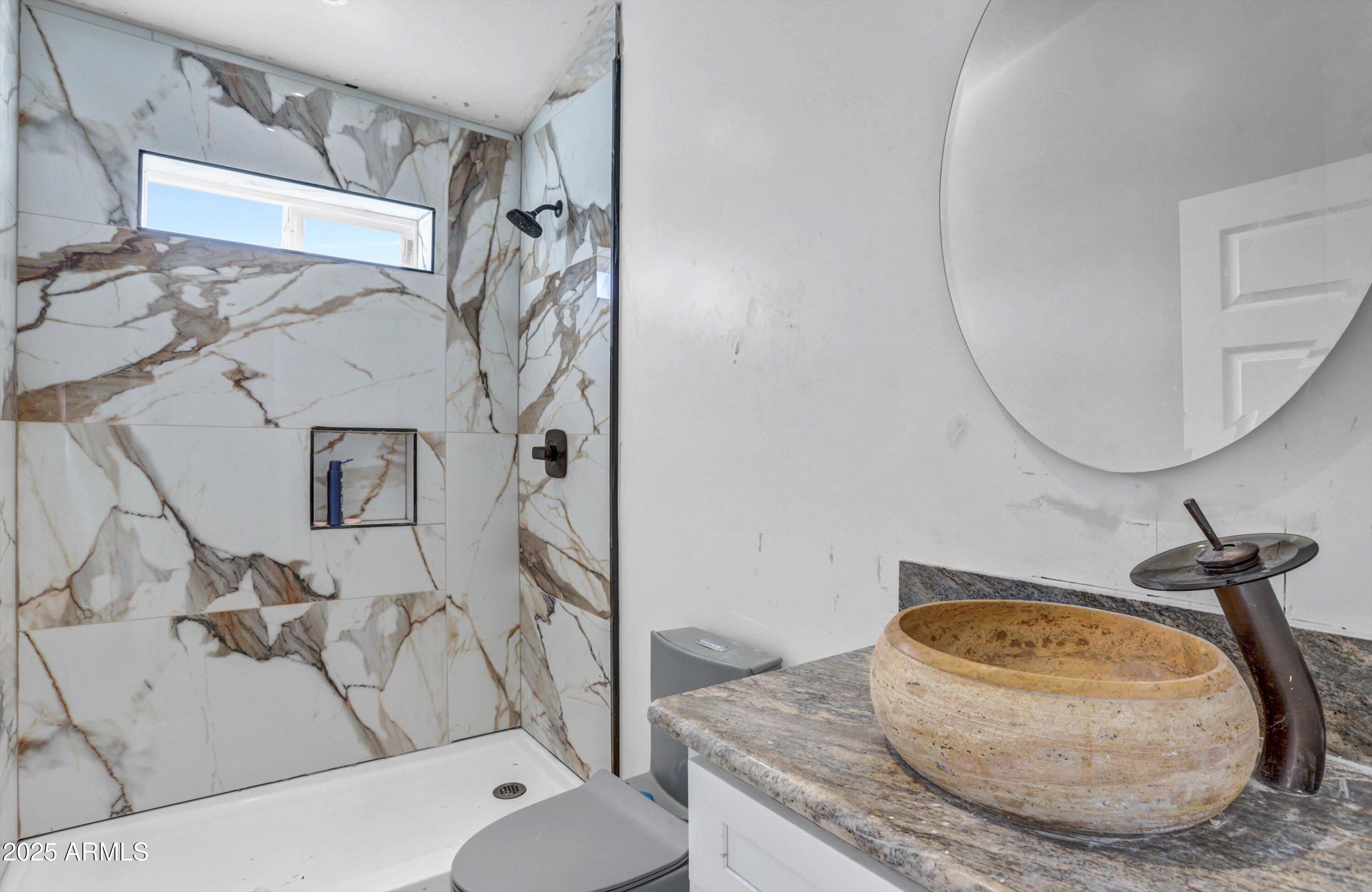 317 West Frontier Street Apache Junction, AZ 85120 - Photo 18 of 28 a bathroom with a granite countertop sink and a mirror