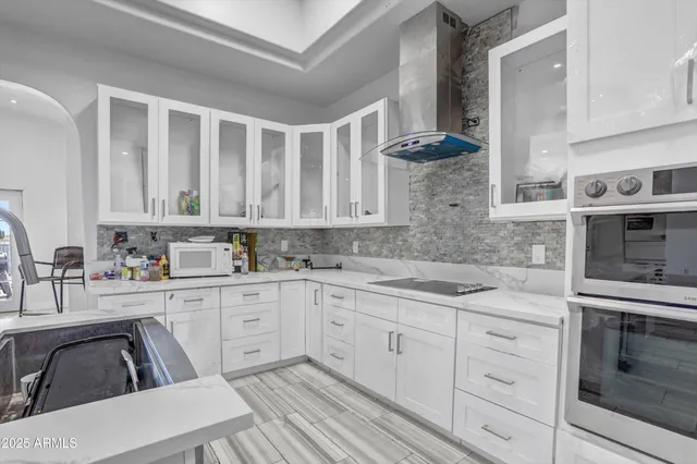 a kitchen with granite countertop white cabinets and white appliances