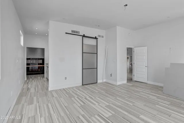 a view of empty room with wooden floor