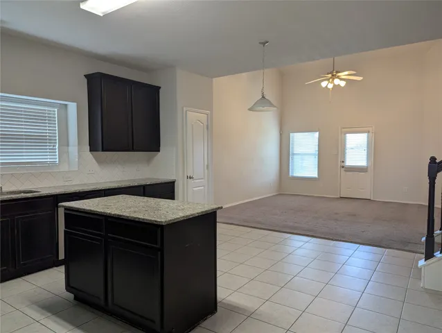 a kitchen with a sink granite counter tops and a window