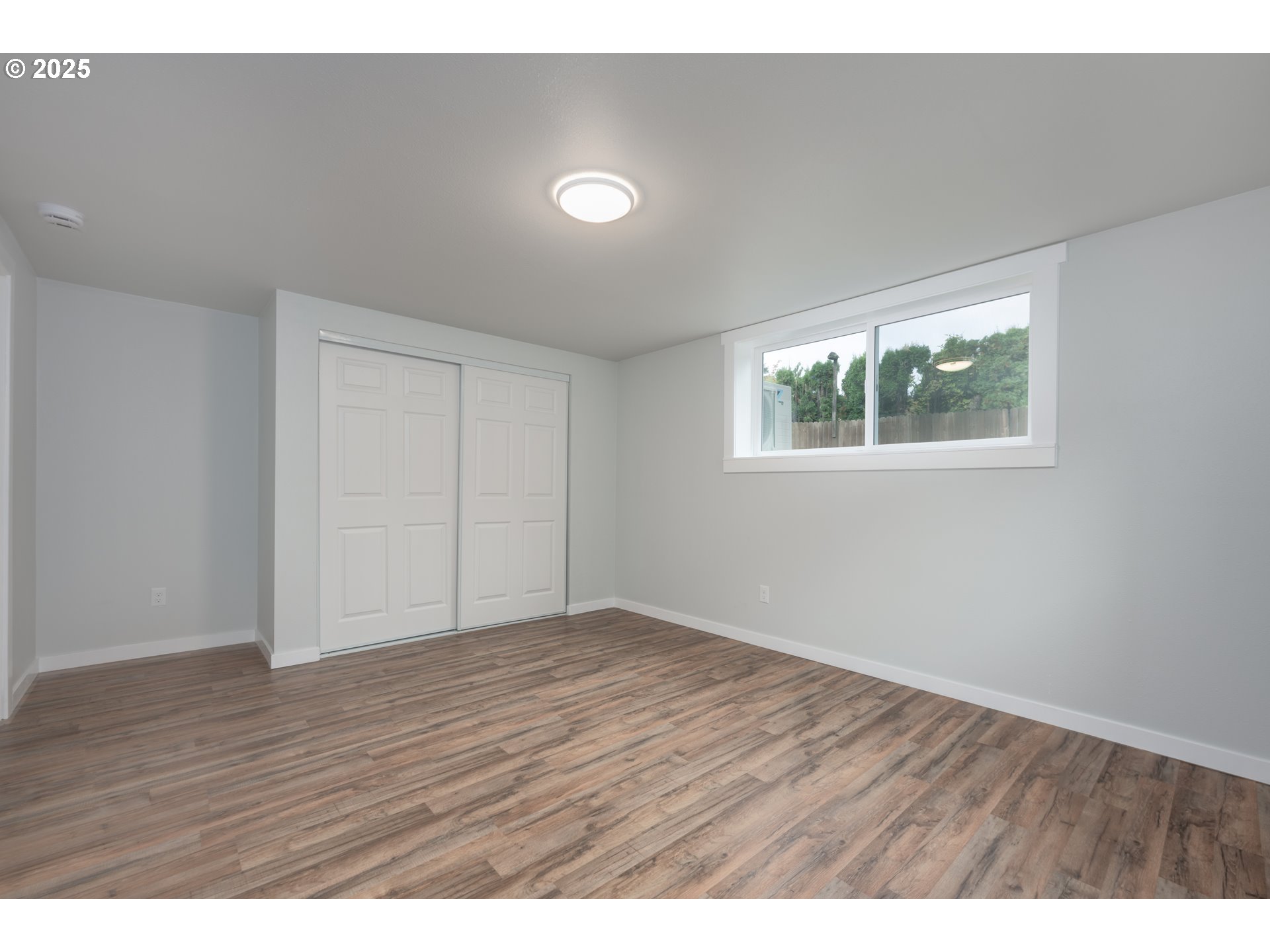 5775 Southeast Cesar Estrada Chavez Boulevard Portland, OR 97202 - Photo 31 of 43 a view of an empty room with wooden floor and a window