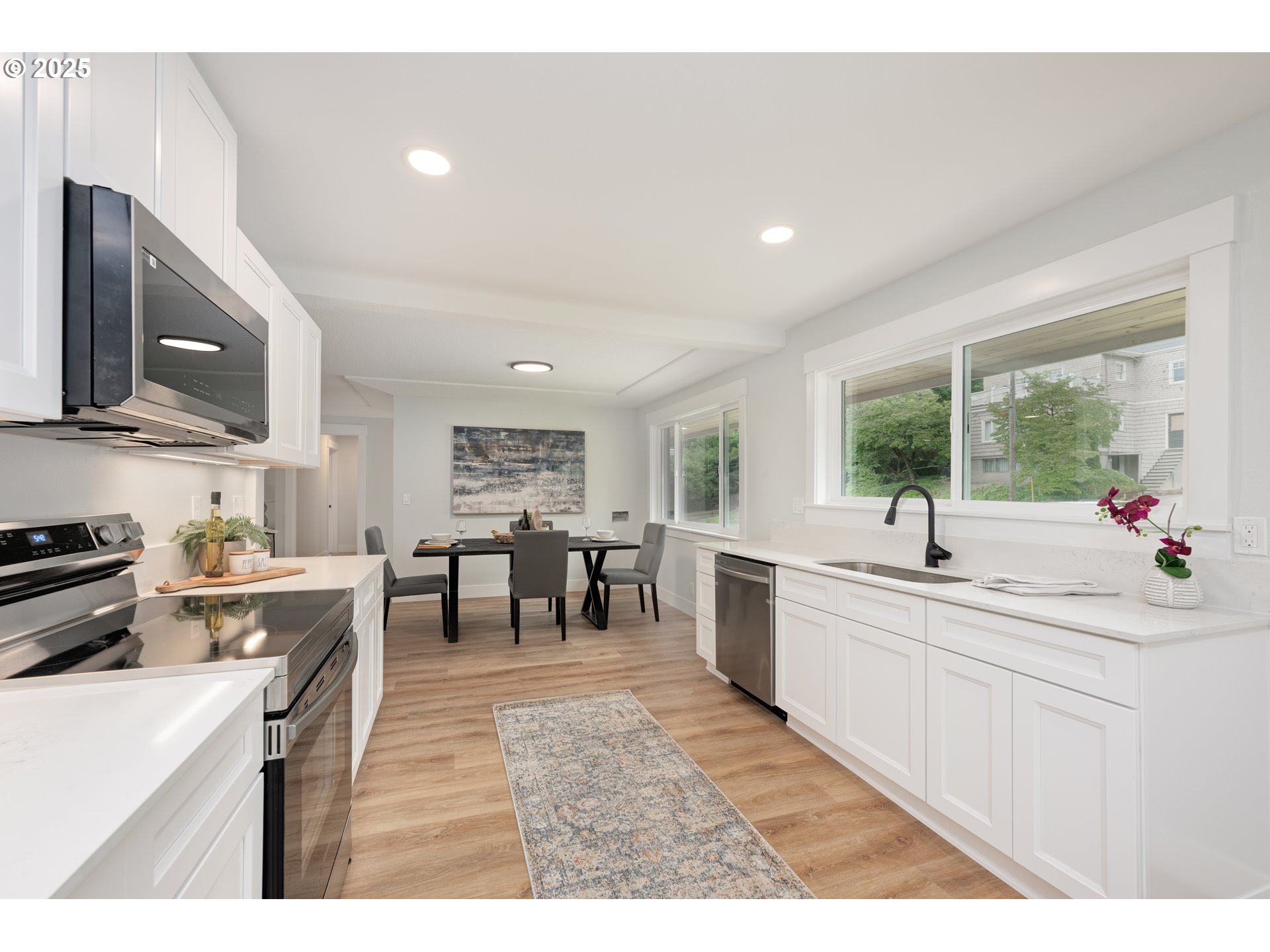 5775 Southeast Cesar Estrada Chavez Boulevard Portland, OR 97202 - Photo 8 of 43 a large kitchen with kitchen island a sink a stove a dining table and chairs