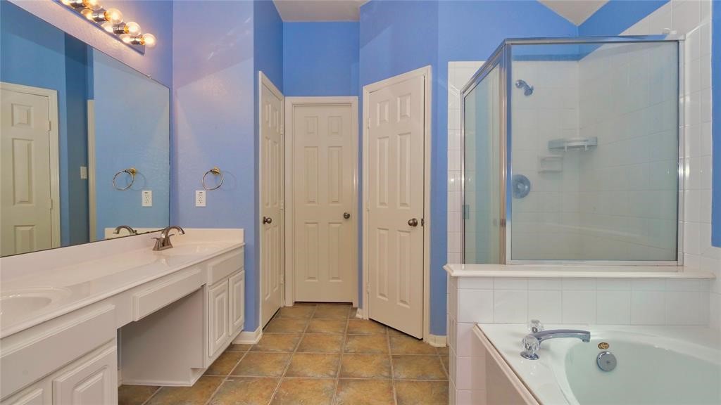 10235 Riderdale Park Lane Houston, TX 77070 - Photo 14 of 16 a bathroom with a tub sink and mirror