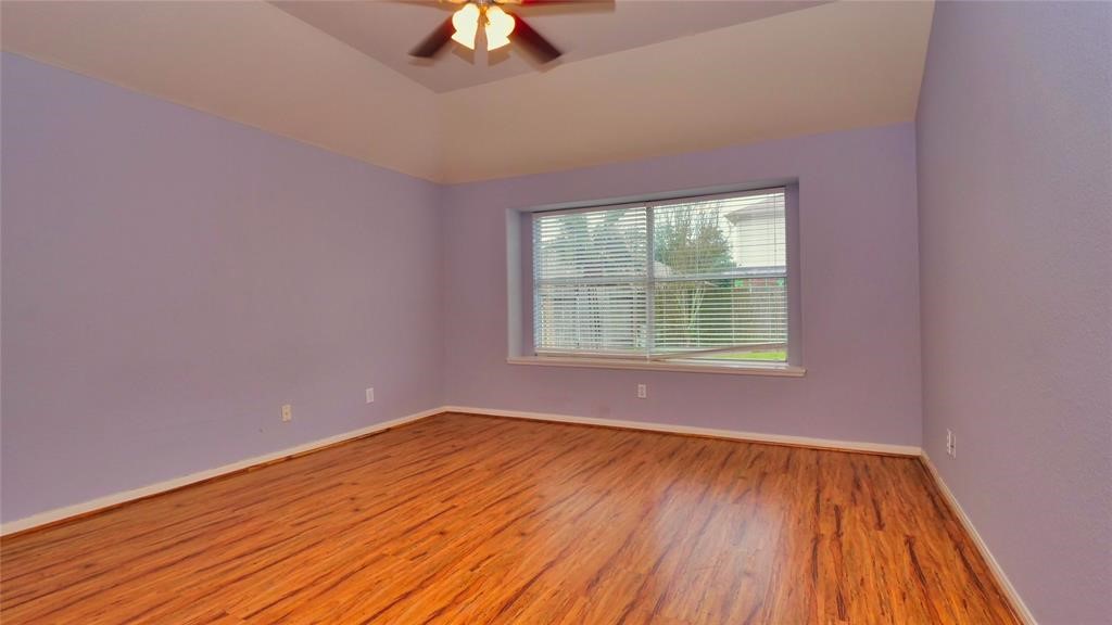 10235 Riderdale Park Lane Houston, TX 77070 - Photo 9 of 16 a view of an empty room with wooden floor and a window