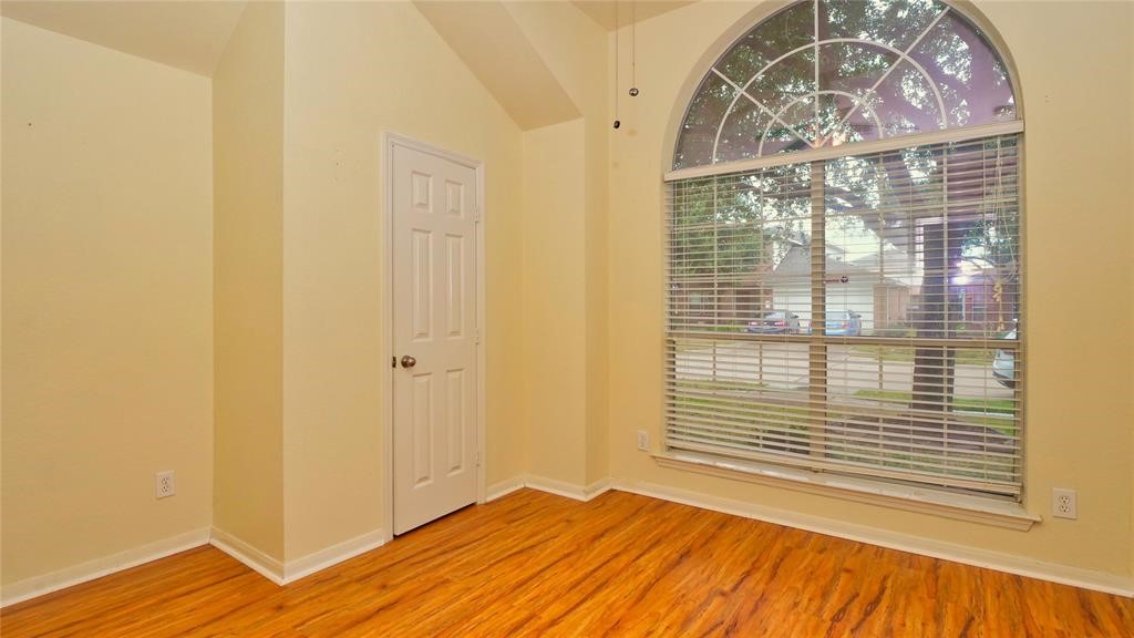 10235 Riderdale Park Lane Houston, TX 77070 - Photo 10 of 16 a view of an empty room with wooden floor and a window