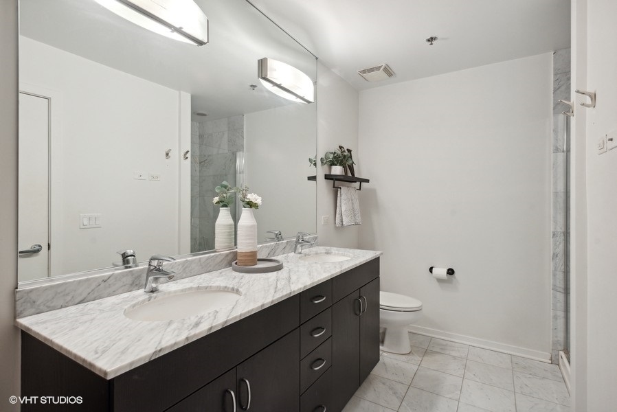 123 South Green Street, Unit 805B Chicago, IL 60607 - Photo 12 of 18 a bathroom with a granite countertop sink and a mirror