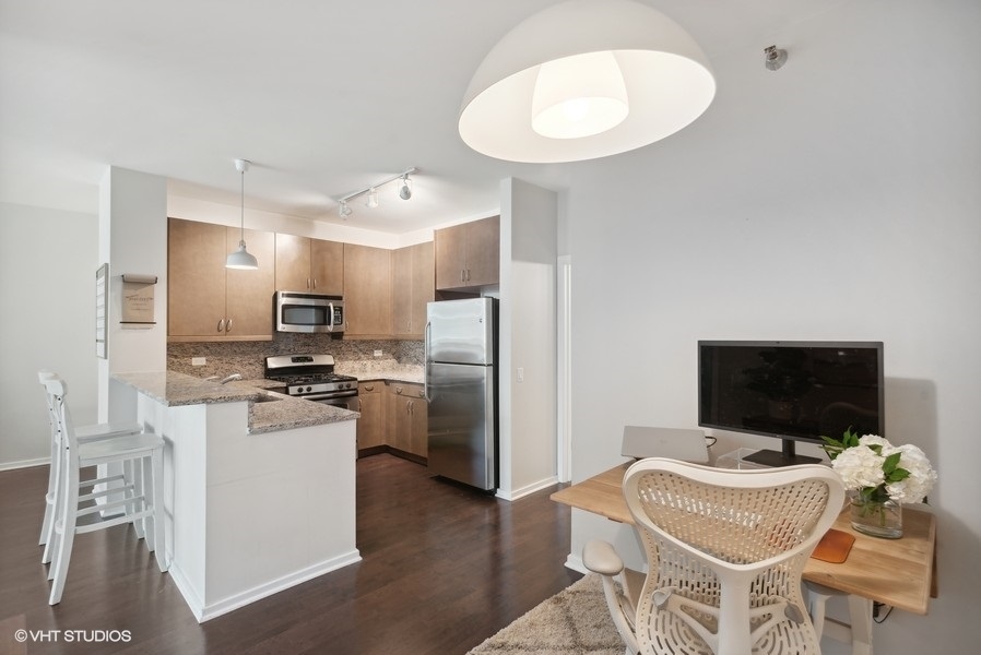123 South Green Street, Unit 805B Chicago, IL 60607 - Photo 7 of 18 a kitchen with stainless steel appliances a stove a refrigerator and a dining table