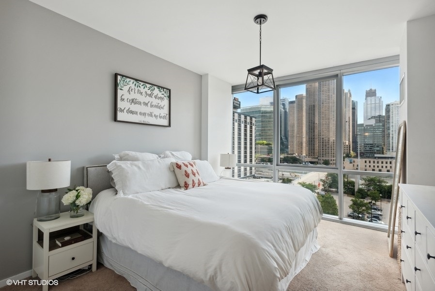 123 South Green Street, Unit 805B Chicago, IL 60607 - Photo 9 of 18 a bedroom with a bed a window and a chandelier