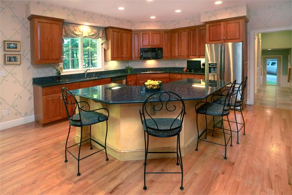 63 Sheffield Road Boxford, MA 01921 - Photo 6 of 30 a kitchen with stainless steel appliances granite countertop a stove a refrigerator a microwave oven with a dining table and chairs with wooden floor