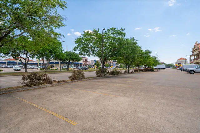 a view of road with card parked on road and trees