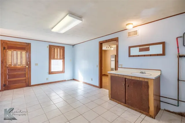 a view of a kitchen with an empty room and window
