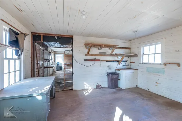 a view of empty room with wooden floor and windows