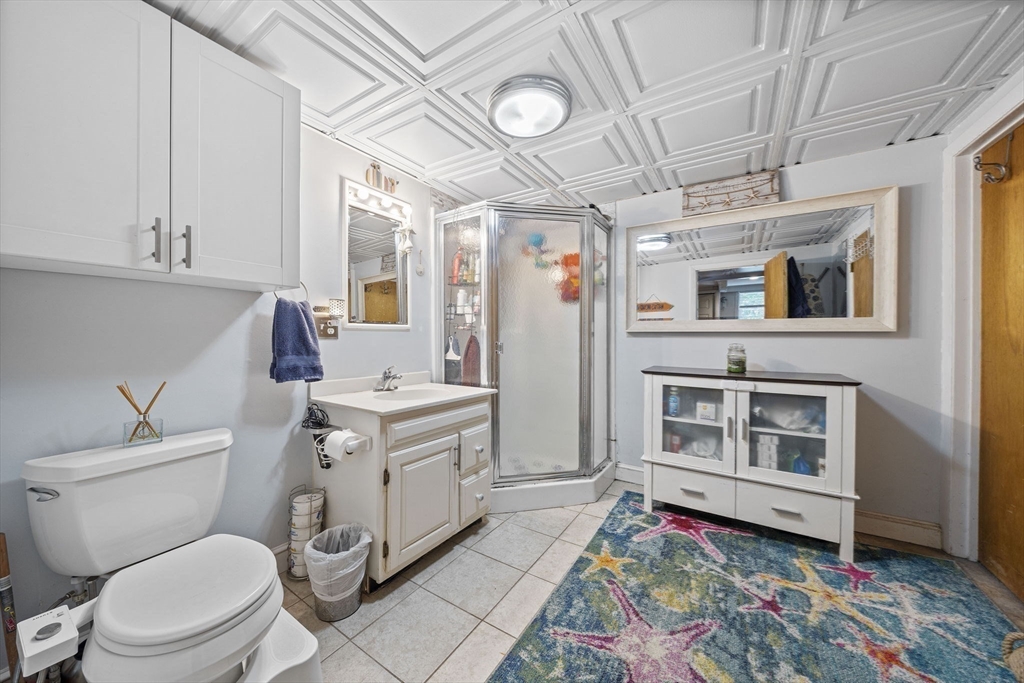 15 D Street Hull, MA 02045 - Photo 20 of 42 a bathroom with a sink mirror vanity and toilet