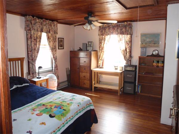 55 Marion Road Scituate, MA 02066 - Photo 14 of 16 a bedroom with a bed next to a window with chair and front door