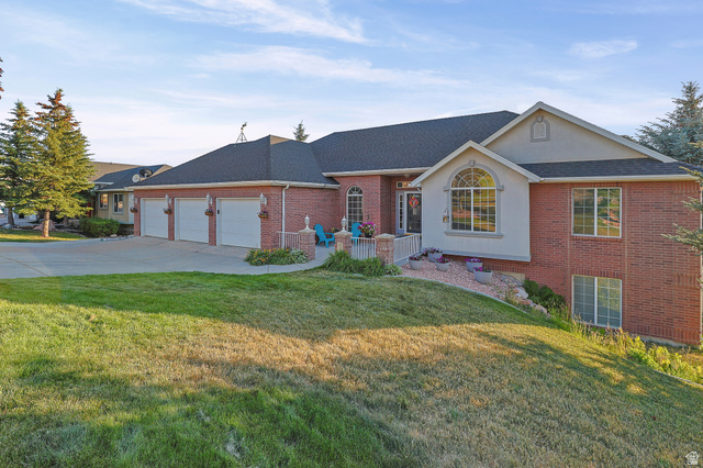 Brick exterior with a three-car garage and a paved driveway