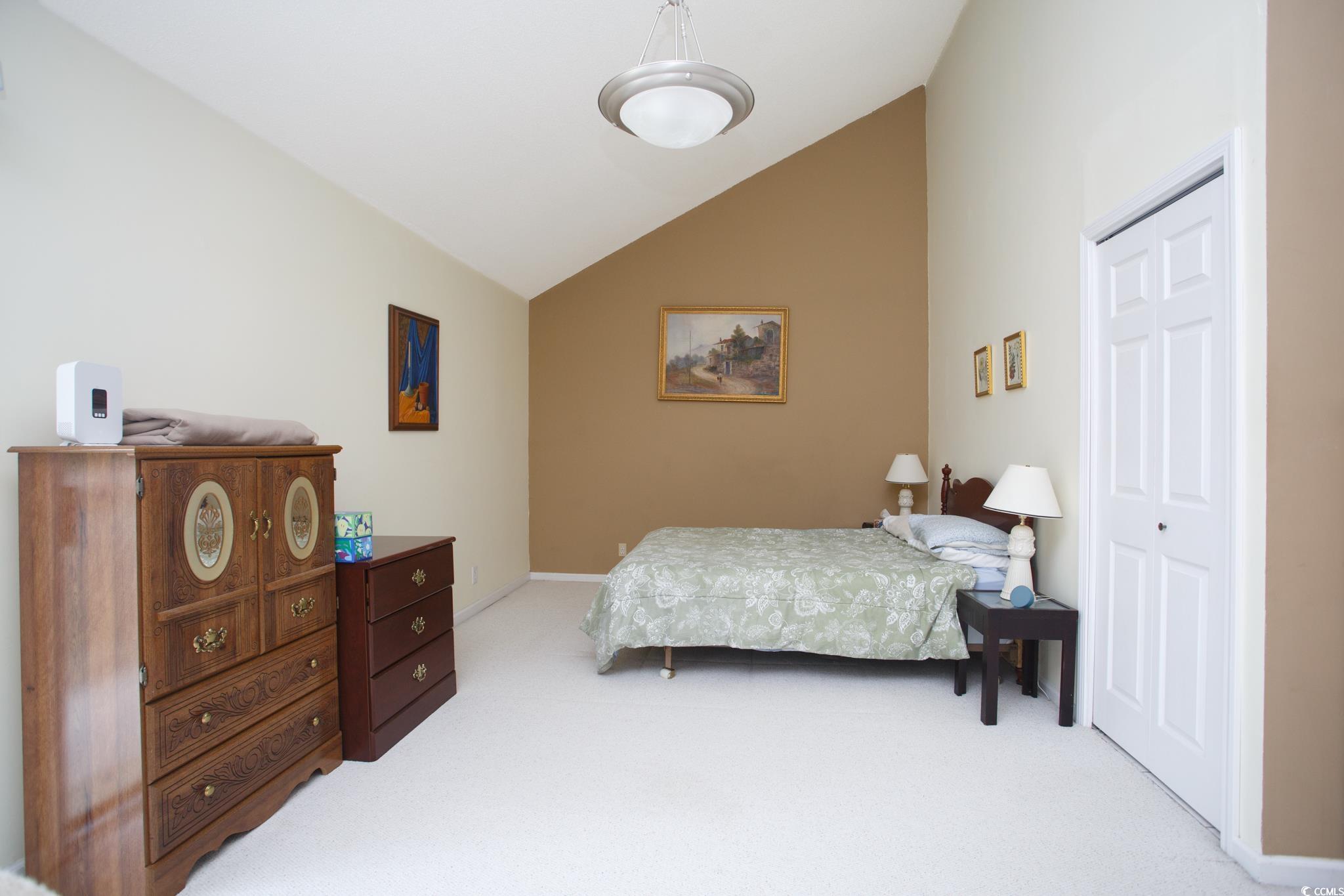 1356 Glenns Bay Road, Unit 201B Surfside Beach, SC 29575 - Photo 27 of 37 Bedroom with lofted ceiling, light carpet, and a c