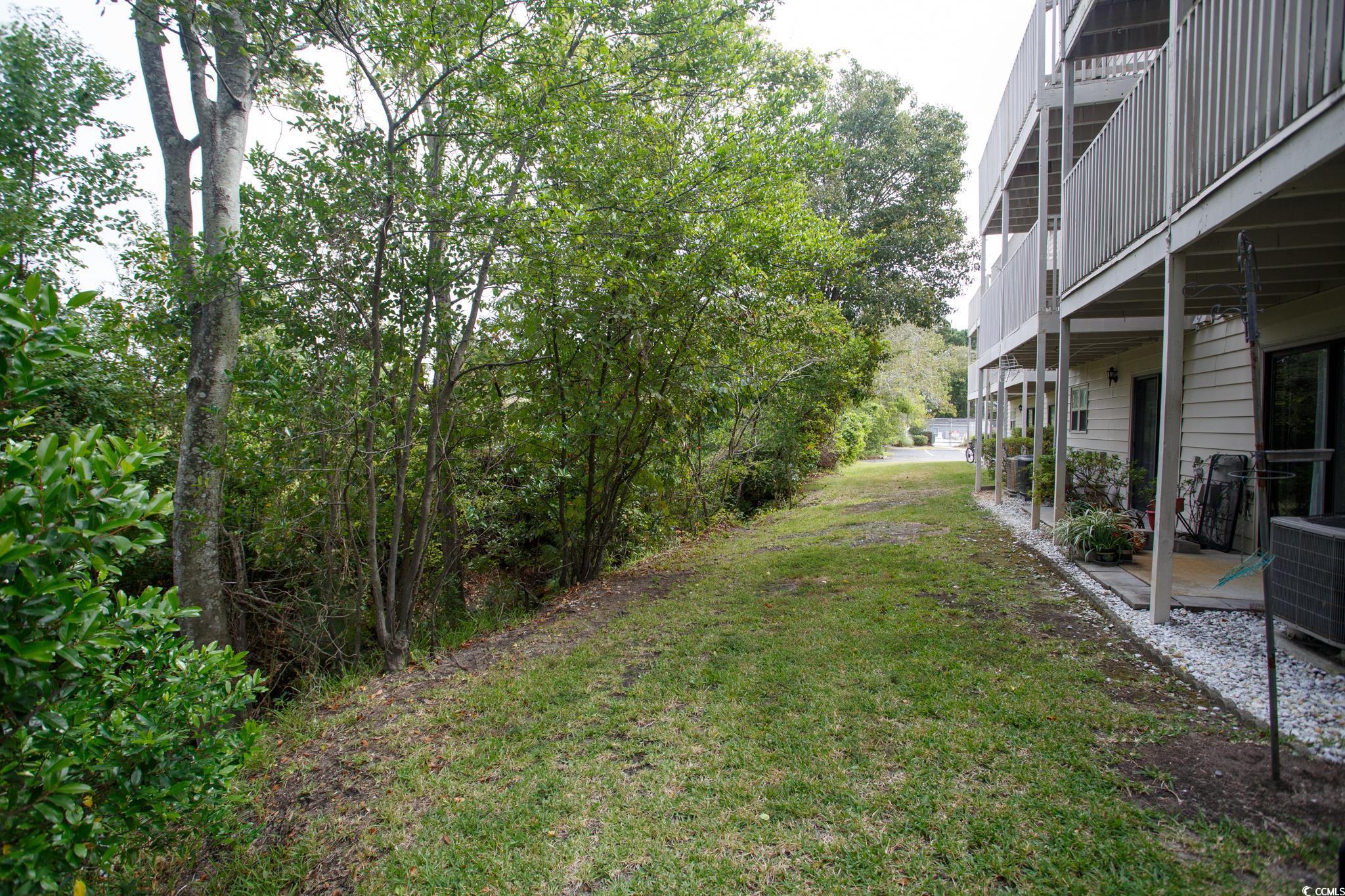 1356 Glenns Bay Road, Unit 201B Surfside Beach, SC 29575 - Photo 33 of 37 View of grassy yard with a patio