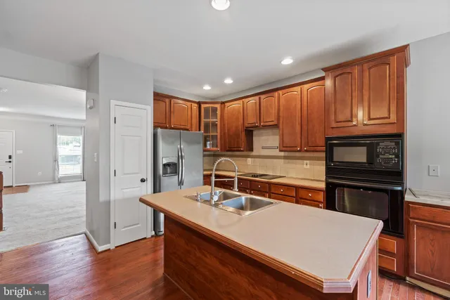 a kitchen with stainless steel appliances granite countertop a sink refrigerator and cabinets