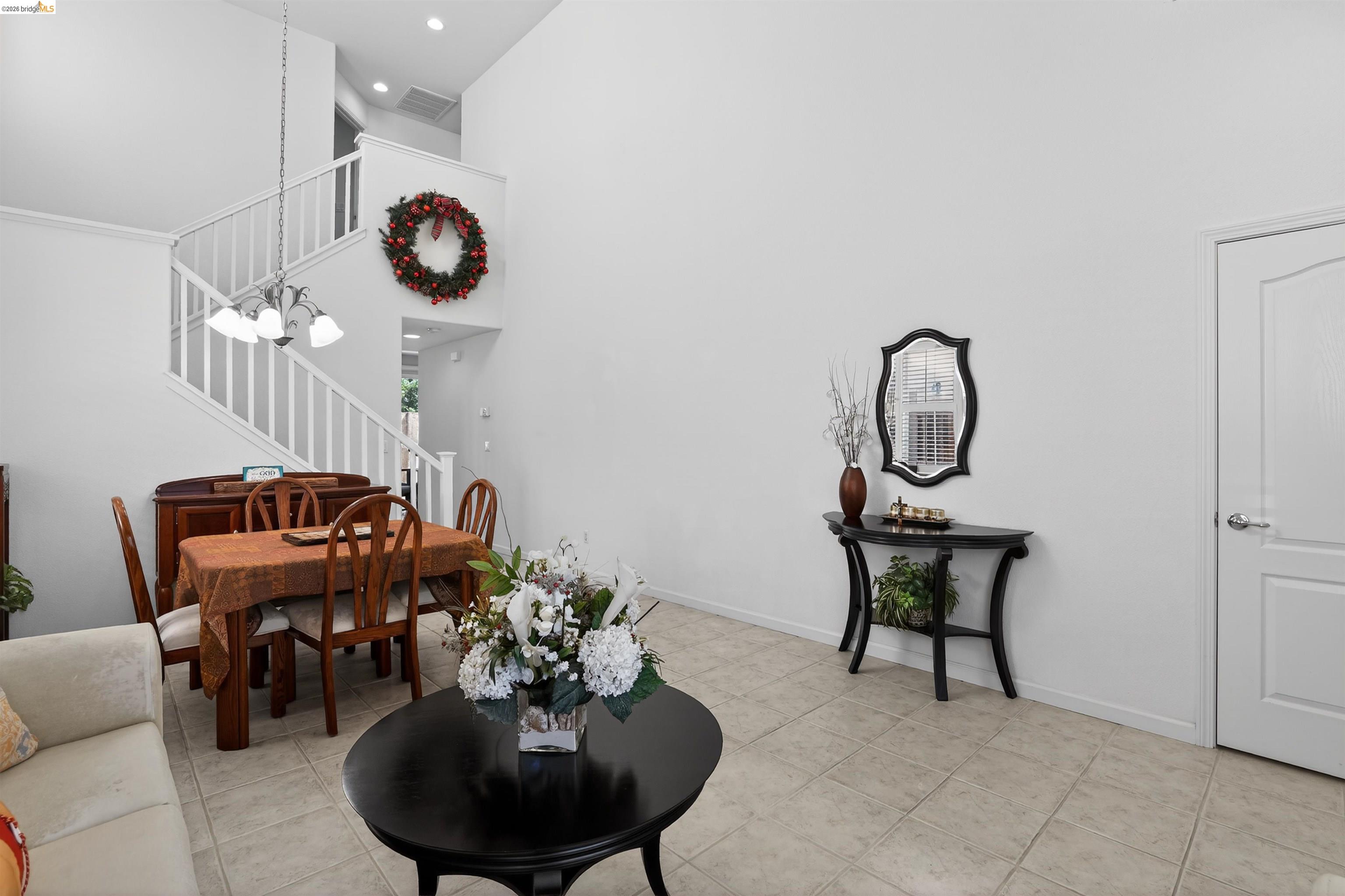 1221 Andrea Way Vallejo, CA 94591 - Photo 5 of 29 Spacious interior featuring a high ceiling, tile flooring, and a staircase with white balusters