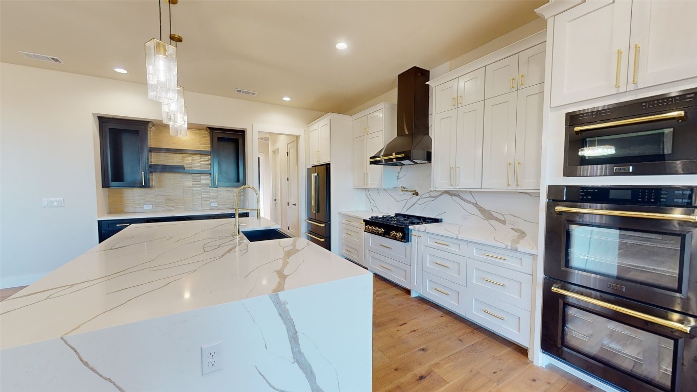 17307 West Reed Park Road Leander, TX 78645 - Photo 6 of 19 a kitchen with stainless steel appliances kitchen island granite countertop a stove and a sink with wooden floor