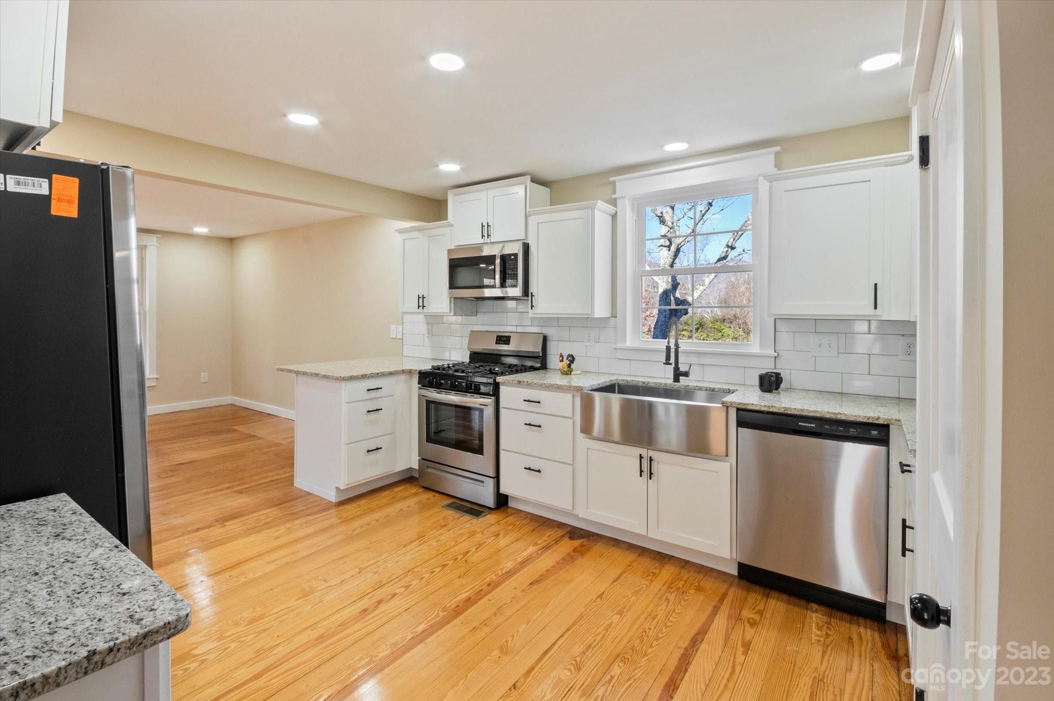 969 Peniel Road Columbus, NC 28722 - Photo 17 of 32 a kitchen with stainless steel appliances granite countertop a stove a sink and a refrigerator