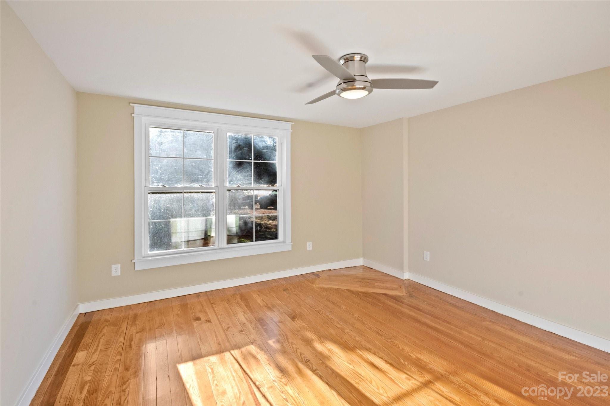 969 Peniel Road Columbus, NC 28722 - Photo 26 of 32 a view of an empty room with wooden floor and a window
