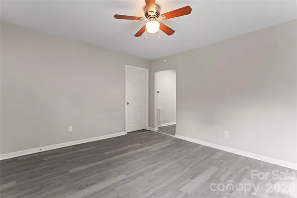 a view of an empty room and chandelier fan