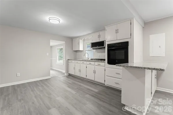 a kitchen with granite countertop white cabinets and appliances
