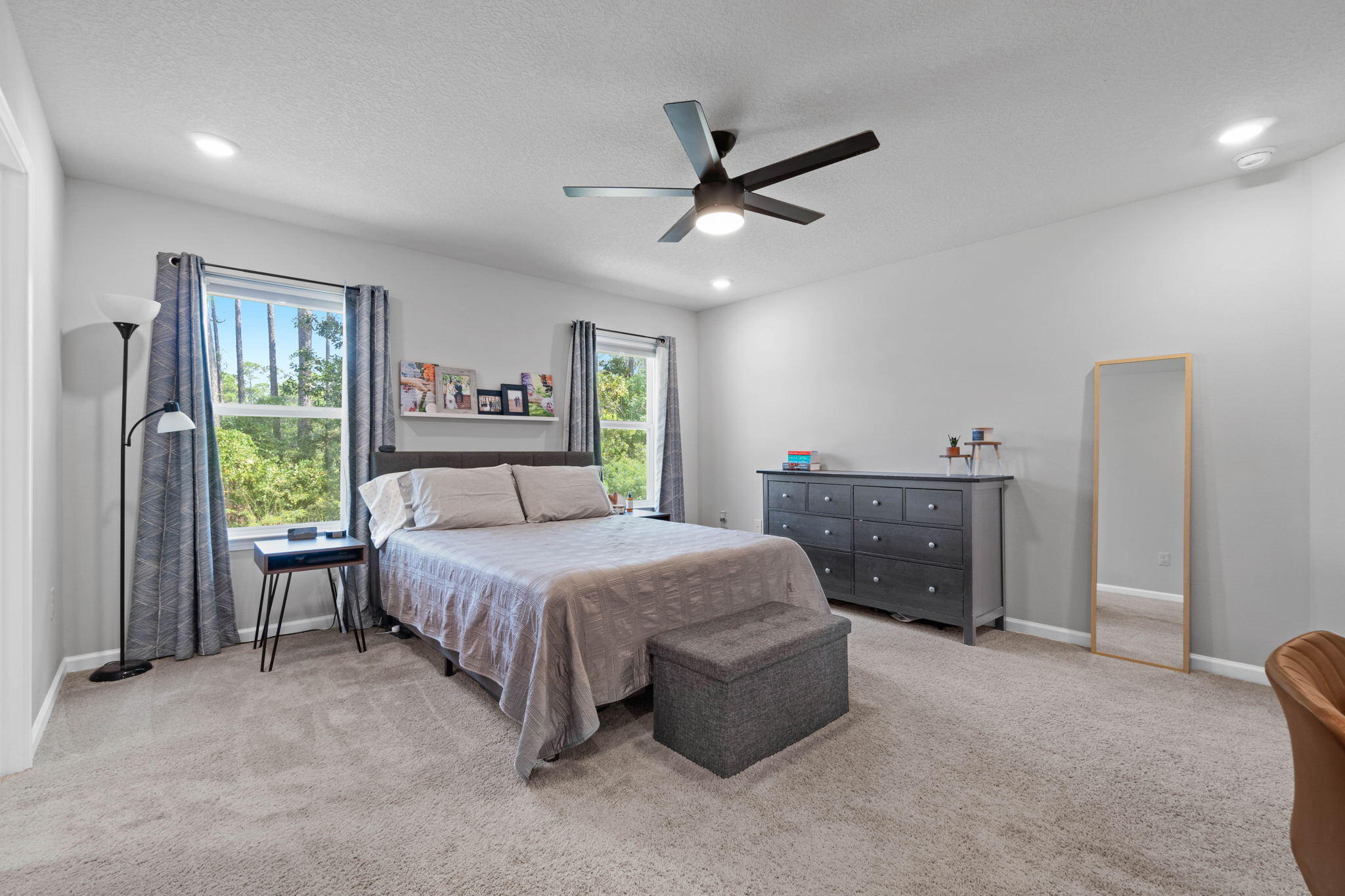 82 American Court Santa Rosa Beach, FL 32459 - Photo 22 of 47 a bedroom with a bed and a chandelier