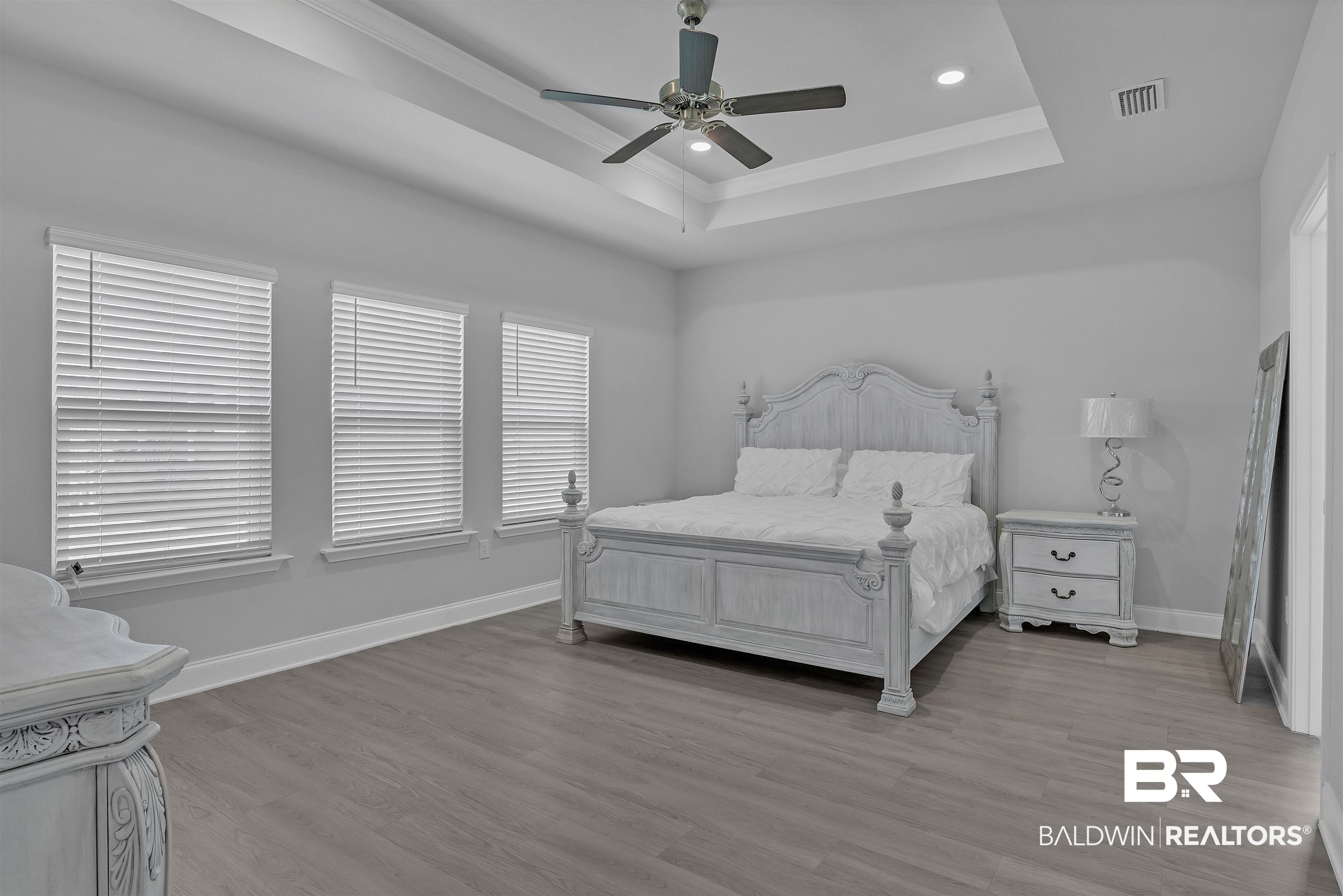 27862 Jade Court Daphne, AL 36526 - Photo 27 of 33 Bedroom featuring light wood finished floors, a tray ceiling, visible vents, baseboards, and ceiling fan