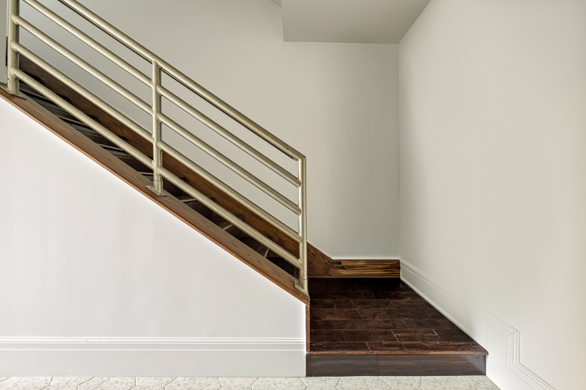 1111 West 12th Street, Unit 107 Austin, TX 78703 - Photo 36 of 38 Modern staircase featuring a stainless steel railing, dark wood-finish treads, and white baseboards
