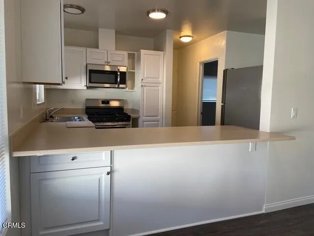 a kitchen with stainless steel appliances a refrigerator sink and microwave