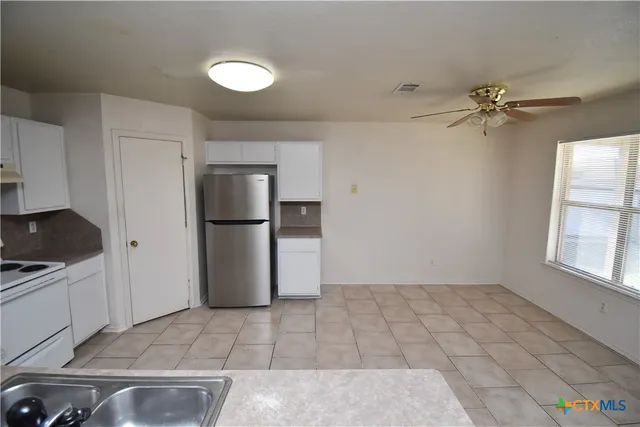 a view of a room with a ceiling fan and a window