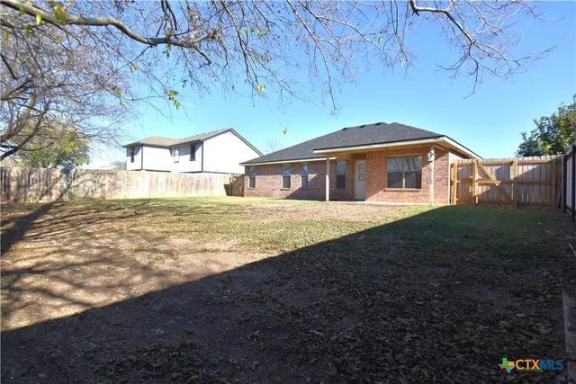 a view of a yard with wooden fence