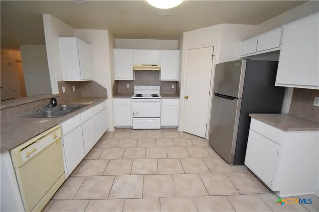 a kitchen with stainless steel appliances a refrigerator sink and microwave