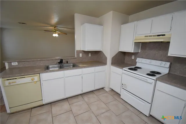 a kitchen with granite countertop cabinets stainless steel appliances and a sink