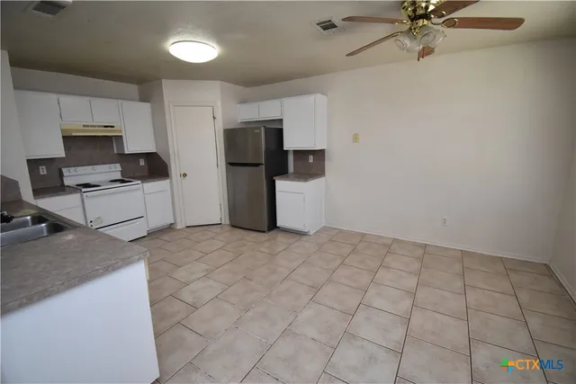 a view of kitchen with stainless steel appliances a refrigerator and a stove top oven
