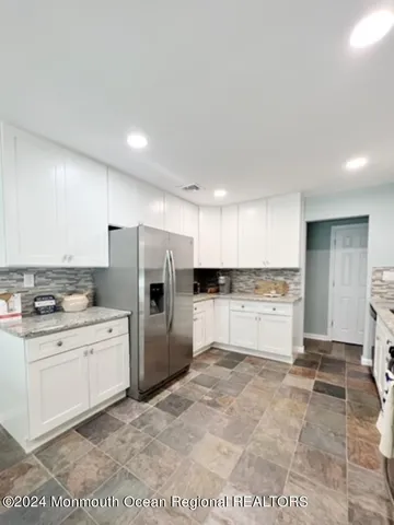 a large white kitchen with a stove a refrigerator and a sink