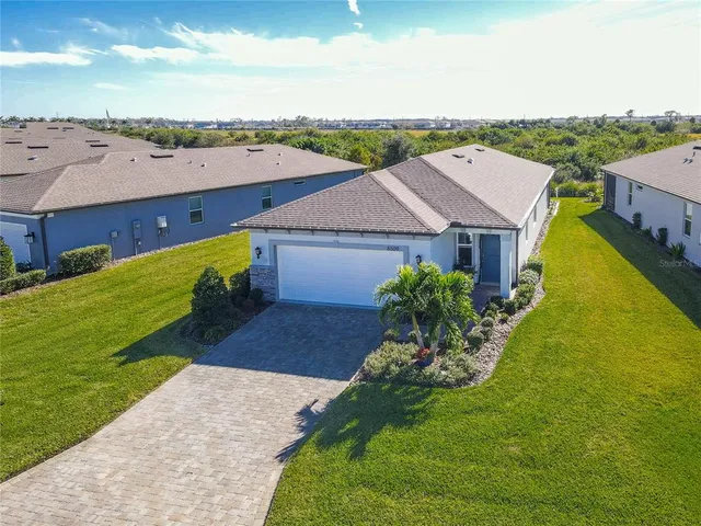an aerial view of residential houses with outdoor space and ocean