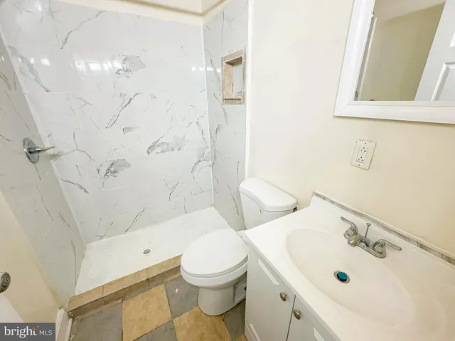 a bathroom with a sink mirror vanity and toilet