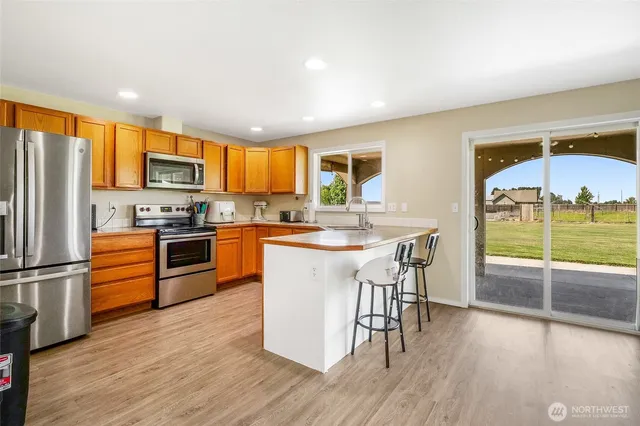 a kitchen with stainless steel appliances granite countertop a stove refrigerator sink and cabinets
