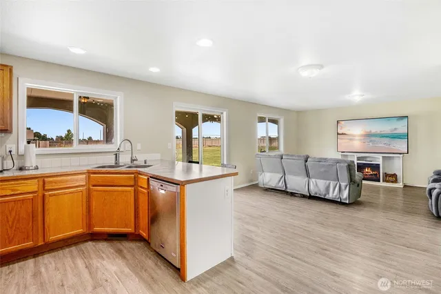 a kitchen with stainless steel appliances granite countertop a refrigerator a stove top oven a sink and dishwasher