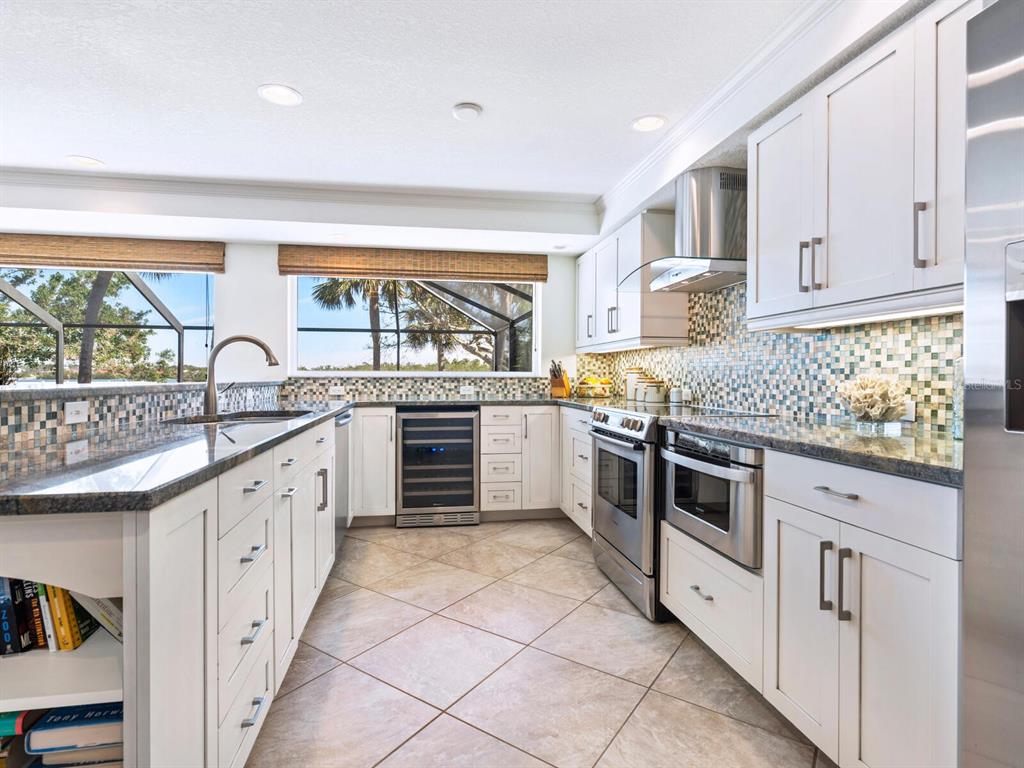 18 North Casey Key Road Osprey, FL 34229 - Photo 15 of 49 a kitchen with granite countertop white cabinets and white appliances